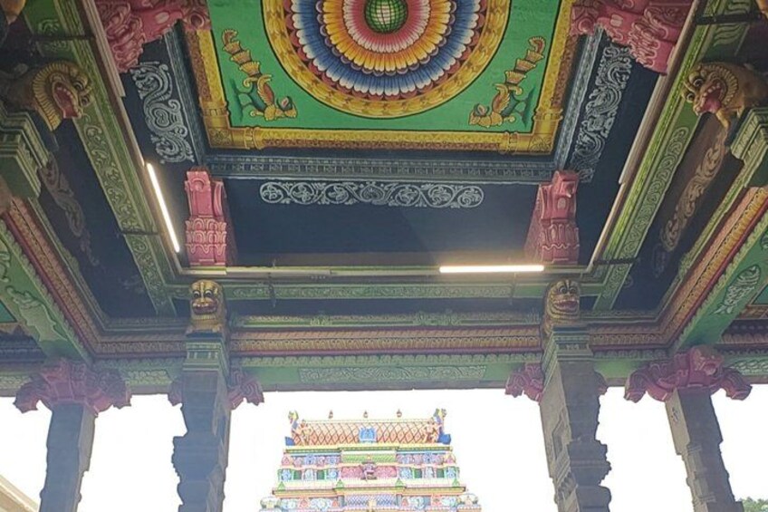 A colorful temple roof with intricate carvings and a traditional tiered structure at the base. 2