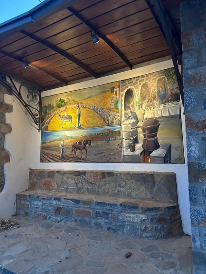 A mural with rural scenes, stone steps, and a wooden roof. 5