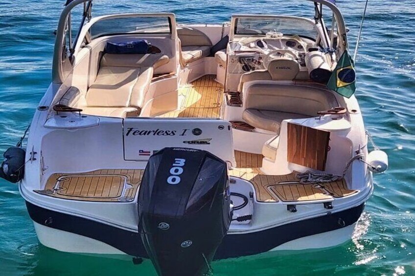 A boat named 'Fearless 1' with a wooden deck, a motor at the stern, and a flag on the bow. 2