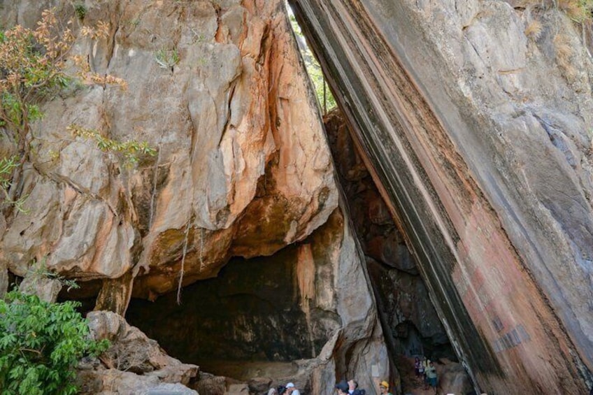 A large rock formation with a cave entrance and a narrow passageway. 2