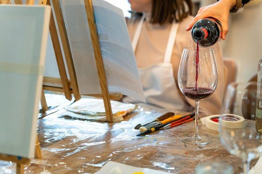 A person pouring red liquid into a glass. 3
