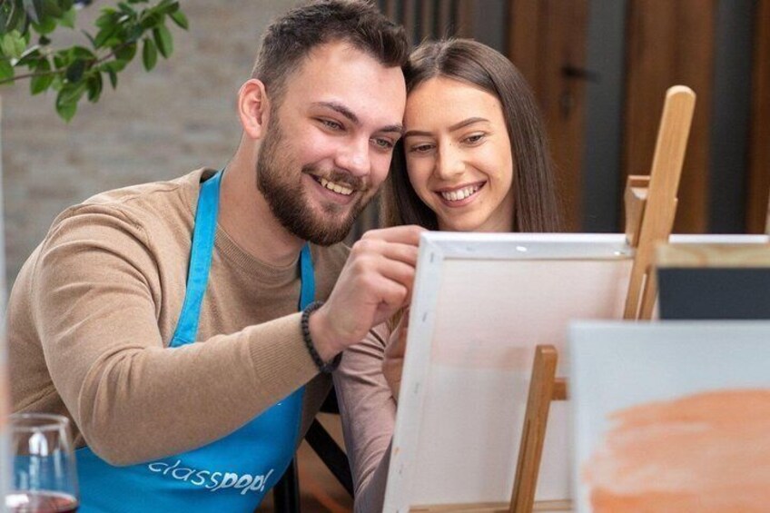 Two people painting, with a canvas and easel visible. 3