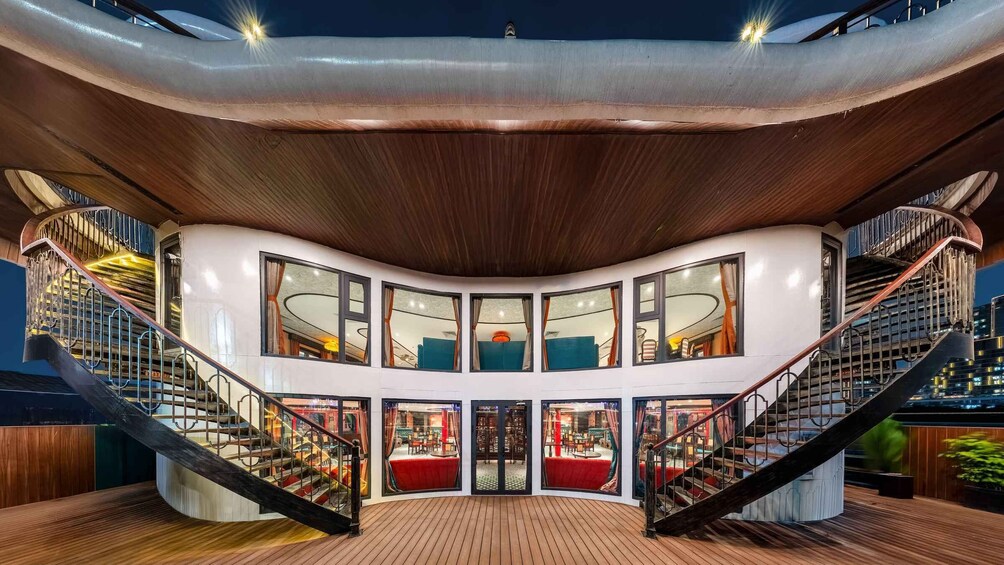 A modern building with a curved wooden ceiling, multiple staircases, and large windows. 5
