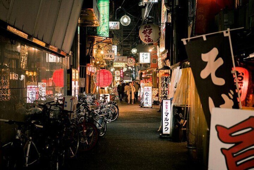 A narrow street lined with shops, bicycles, and traditional lanterns. 3