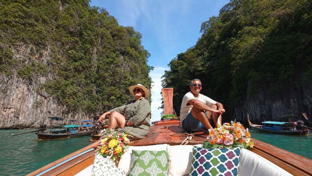A boat with two people, surrounded by water and cliffs. 5