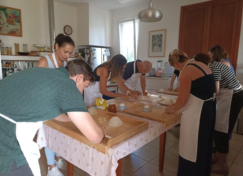 A group of people engaged in a cooking activity, with a kitchen counter and various food items. 4
