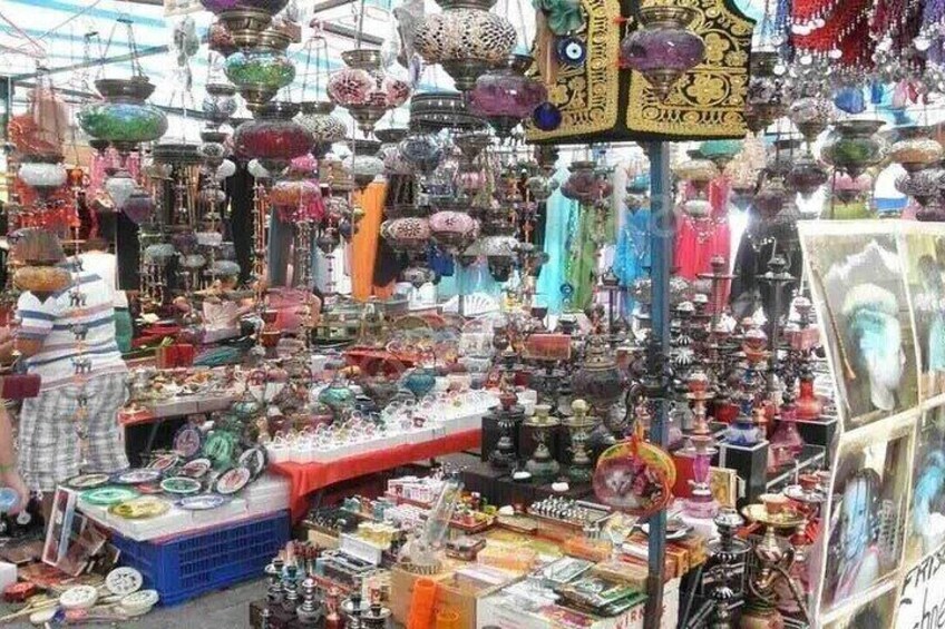 A market with various stalls selling colorful glassware and pottery. 5