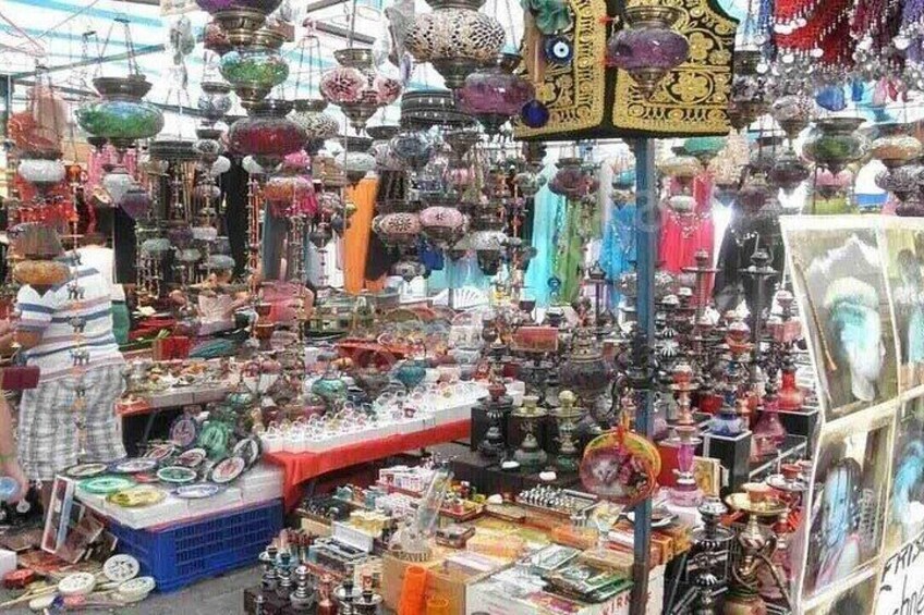 A market with various stalls selling colorful glassware and ceramics. 2