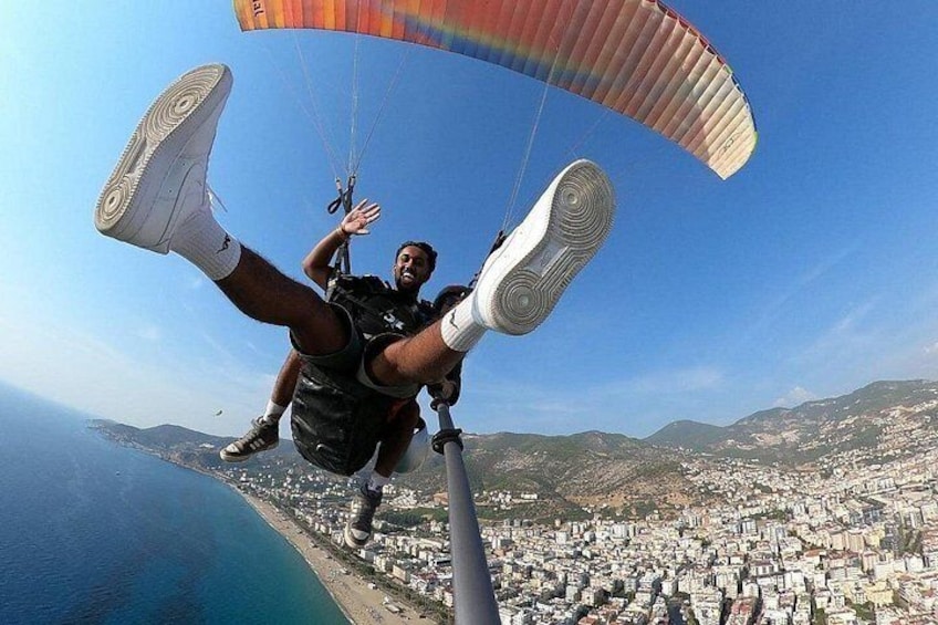 A person skydiving with a parachute, a cityscape below, and a body of water on one side. 3