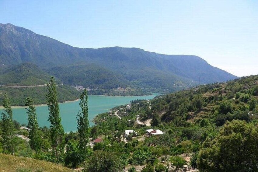 A mountainous landscape with a lake and scattered buildings. 4