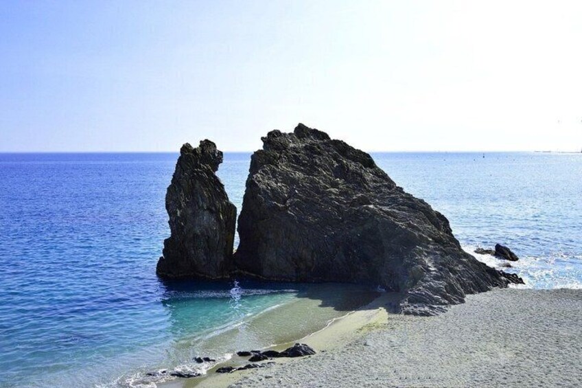A rocky coastline with clear blue waters and a sandy beach. 2