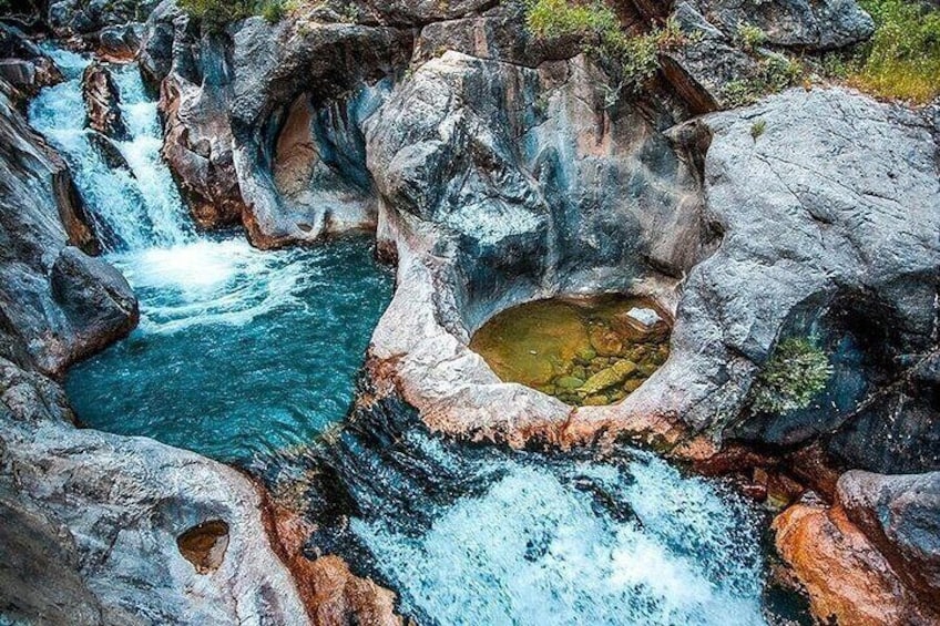 A natural rock formation with a waterfall and a pool. 3
