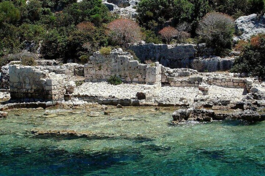 Ancient stone ruins by a clear turquoise sea. 5