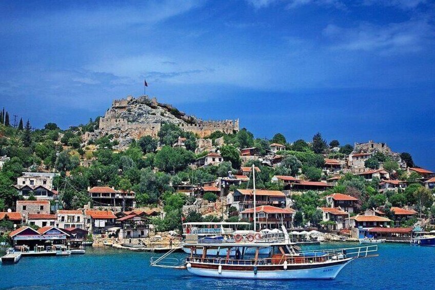 A coastal town with a prominent hilltop fortress, boats docked at the harbor, and residential buildings. 2