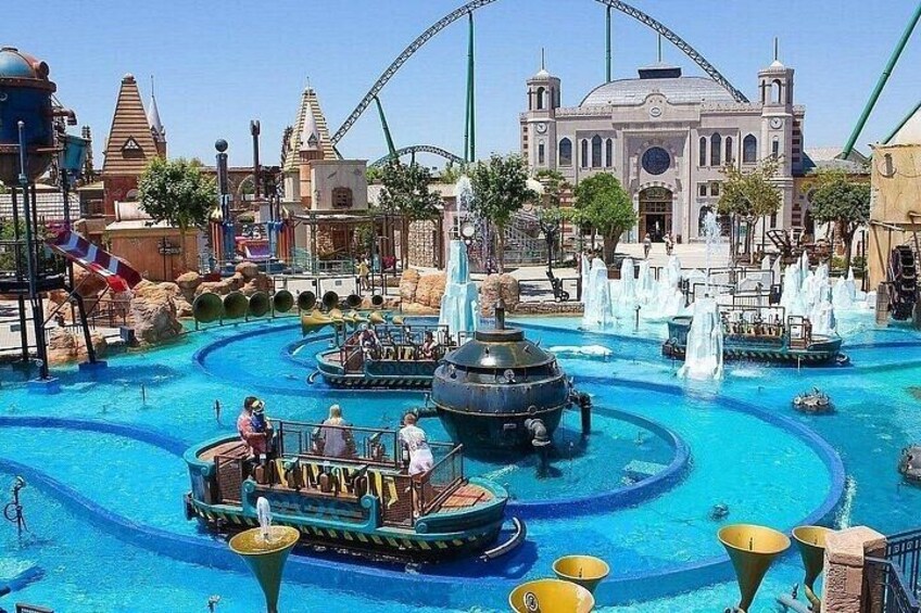 A water park with a large fountain, boats, and a roller coaster in the background. 5