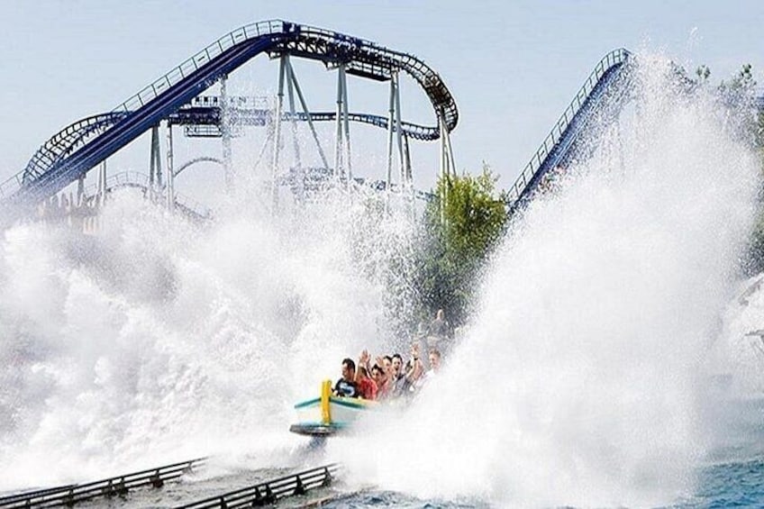 A water ride with a roller coaster in the background. 2