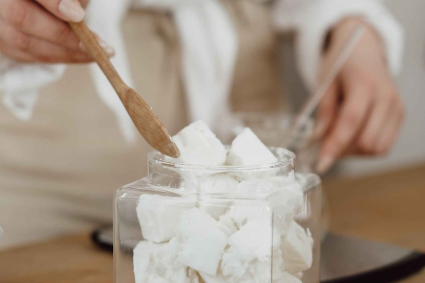 A person stirring white cubes in a clear container. 5