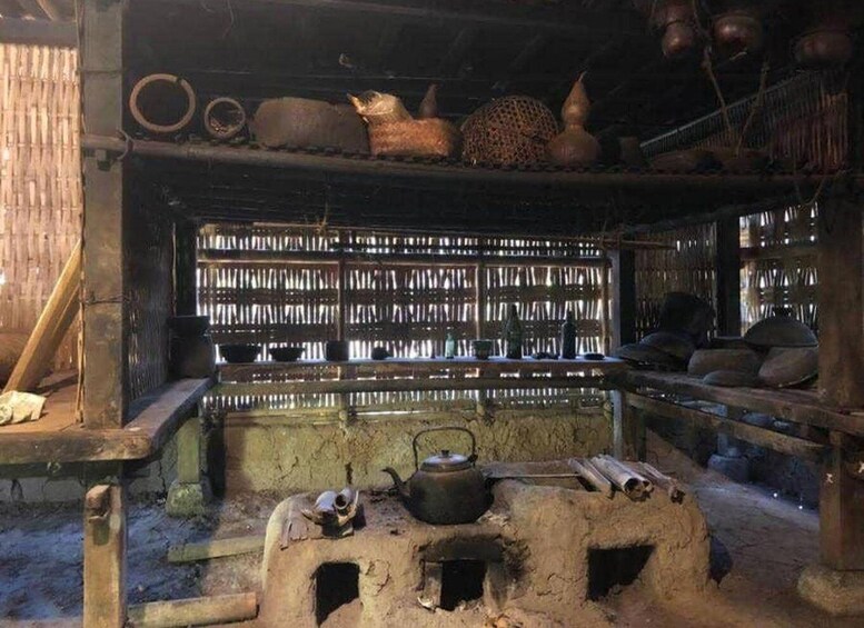 A rustic kitchen with shelves of dried goods, a clay stove, and traditional cookware. 3