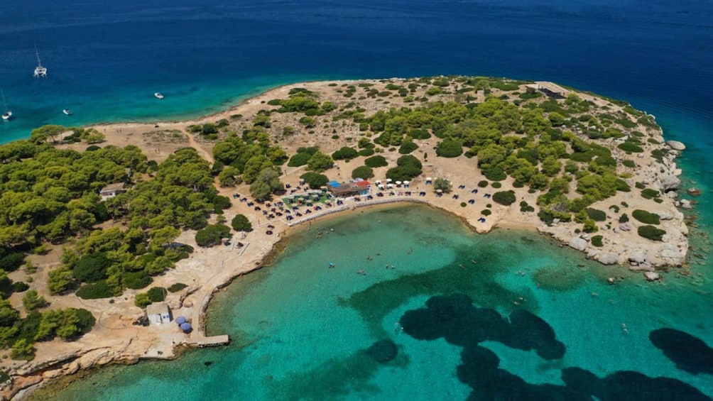 An aerial view of a coastal area with clear turquoise waters, a sandy beach, and scattered trees. 3