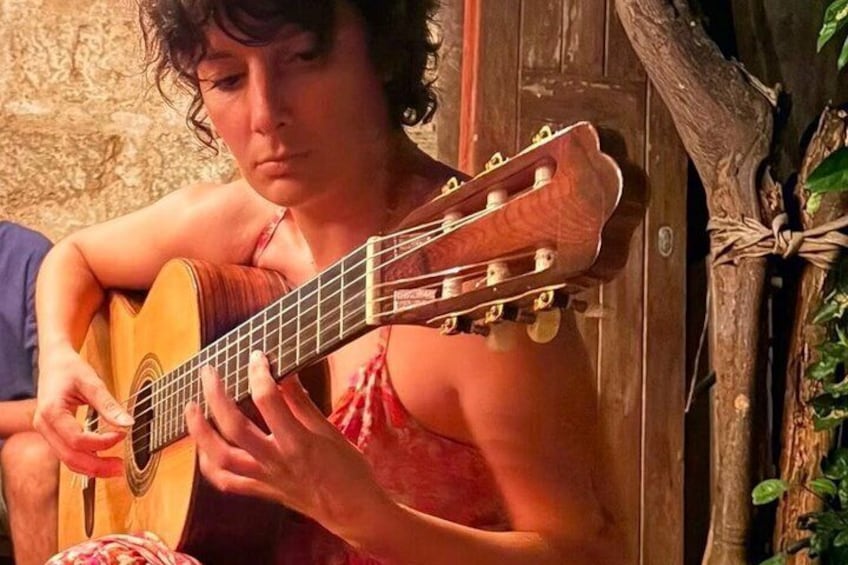 A person playing an acoustic guitar. 1