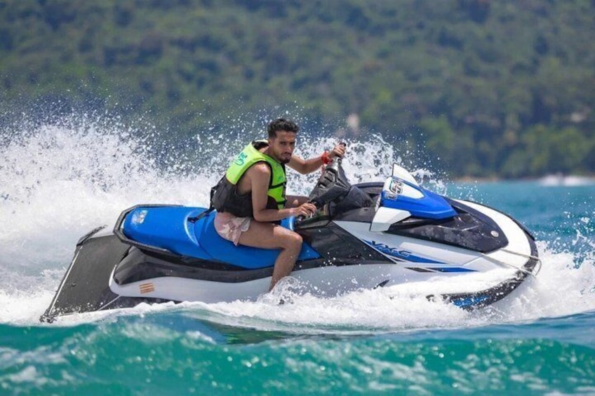 A person jet skiing on a body of water with waves around the jet ski. 5