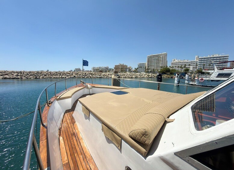 A boat docked at a marina with a cityscape in the background. 3
