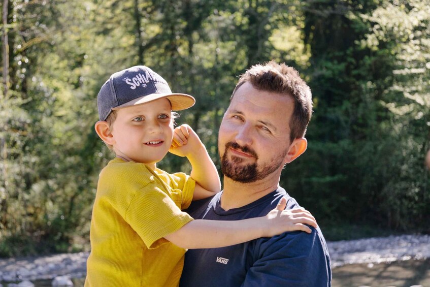 A person in a yellow shirt and a cap with 'SCHWARZENEGGER' on it, holding another person. 5