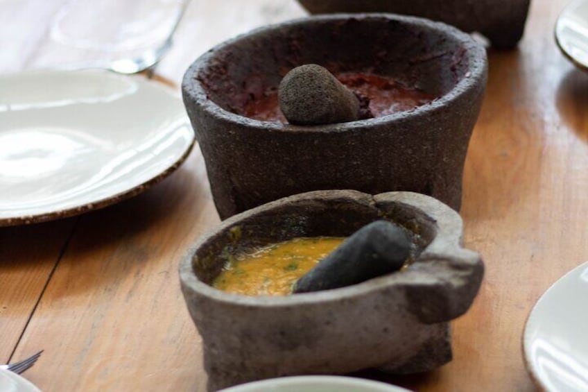 Two stone mortar and pestle sets on a wooden table. 1