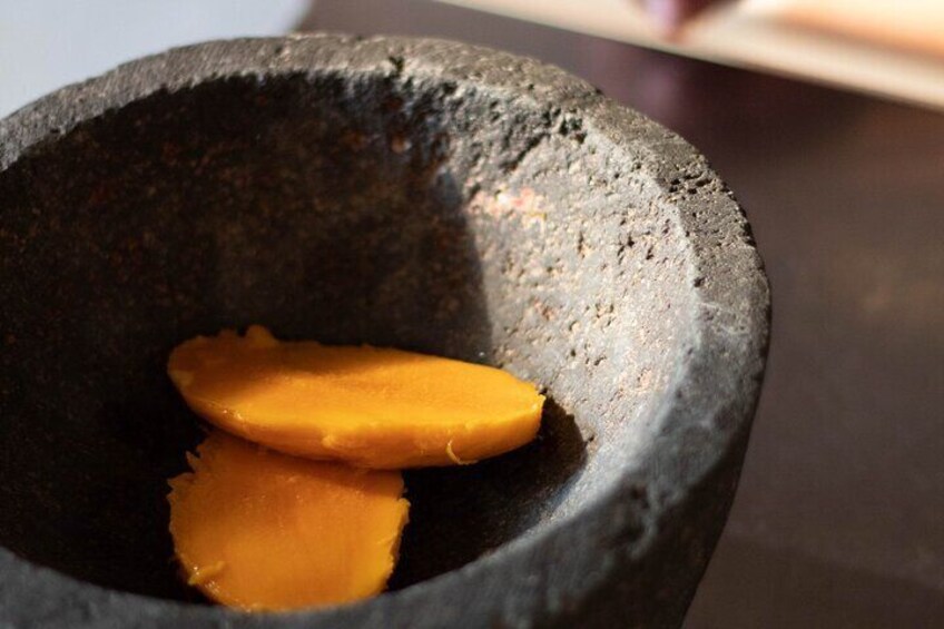 A stone mortar with two pieces of food inside. 2