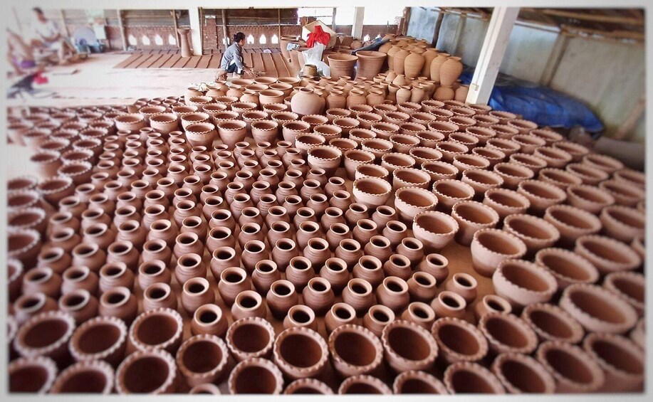 A large number of clay pots arranged in rows in a workshop. 2