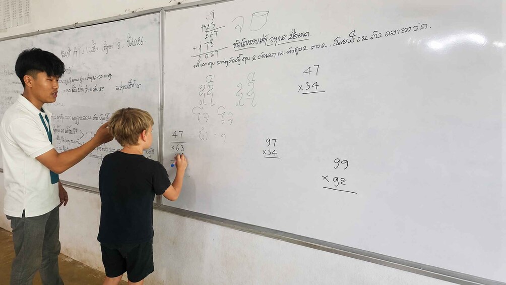 A person teaching mathematics on a whiteboard. 2