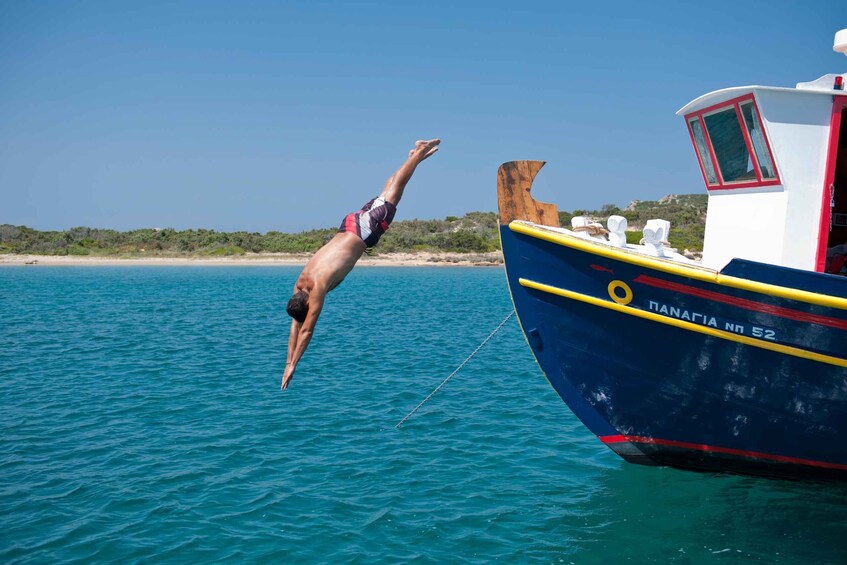A person diving into the water near a boat named 'PANAGIA nn 52'. 2