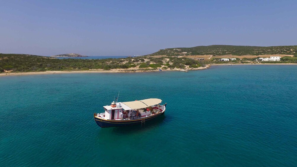 A boat on a turquoise sea with a coastal landscape in the background. 3