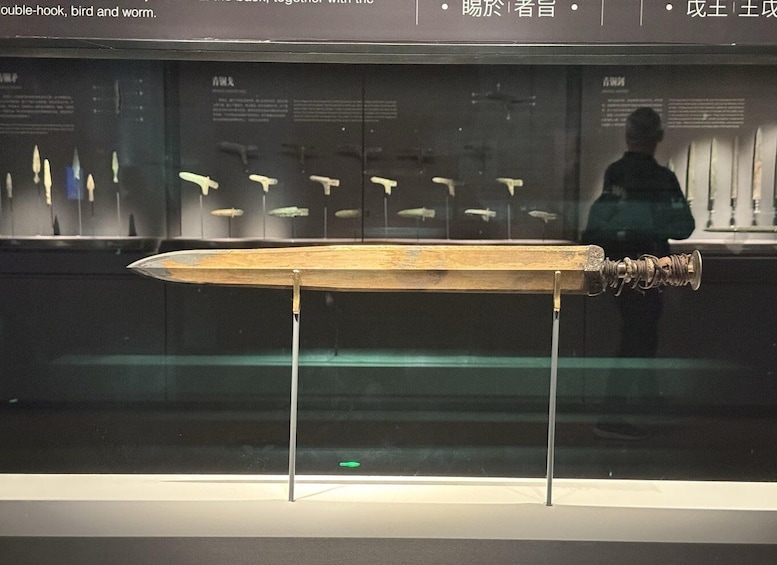 A wooden double-hook fish lure on display in a museum. 3