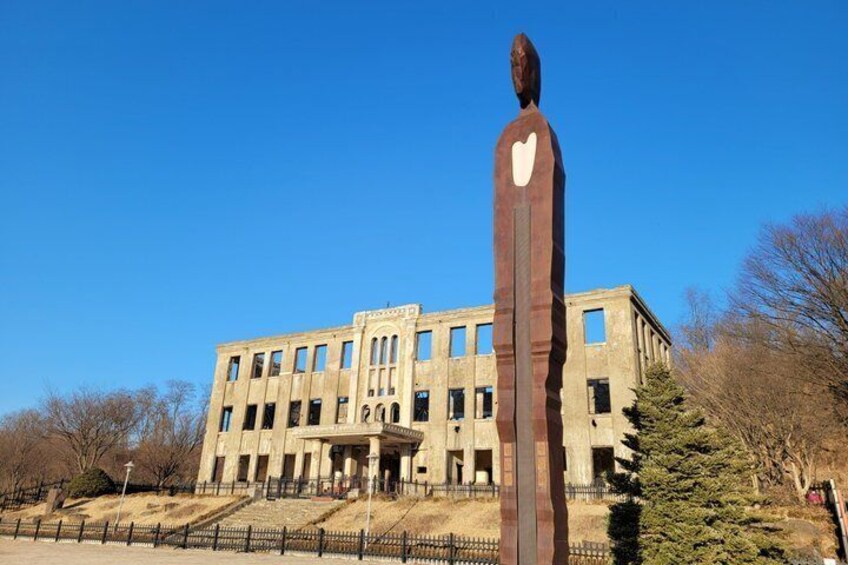 A large building with a statue in front. 2