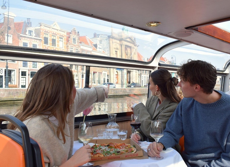 A group of people dining on a boat with a canal view. 3