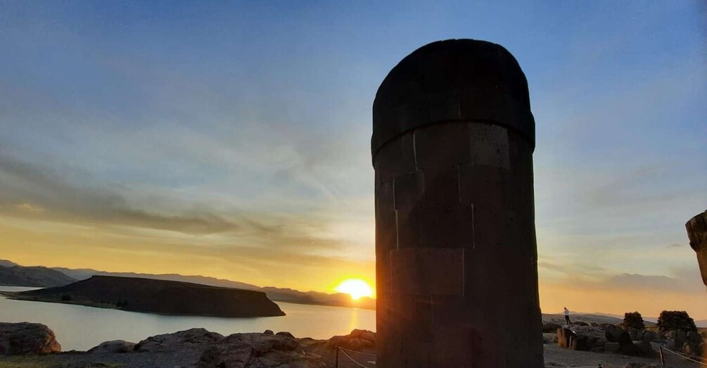 A large cylindrical structure with a sunset in the background. 1