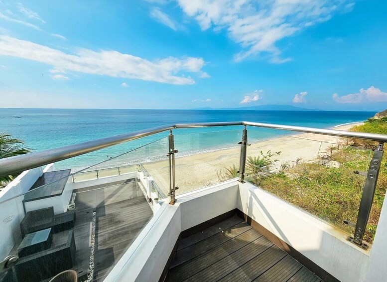 A balcony with a view of a beach and ocean. 4