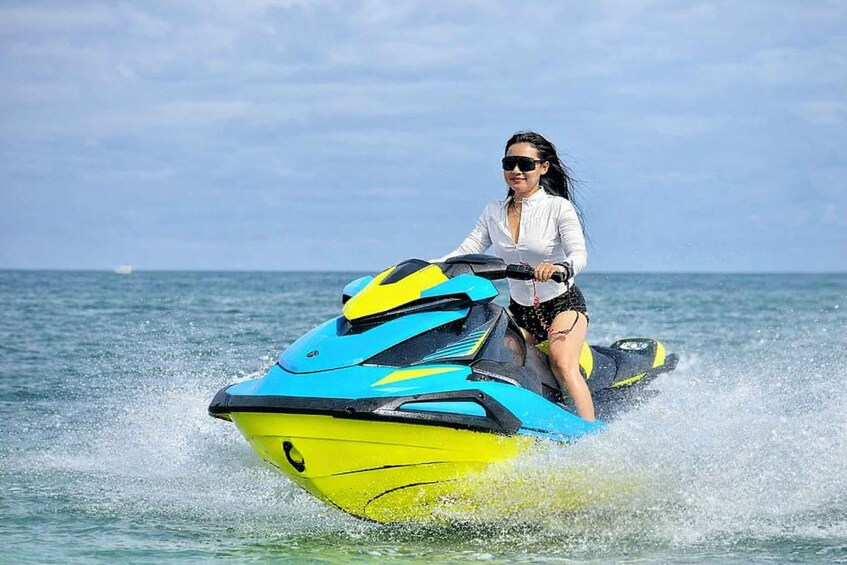 A person riding a yellow and blue jet ski on the water. 3
