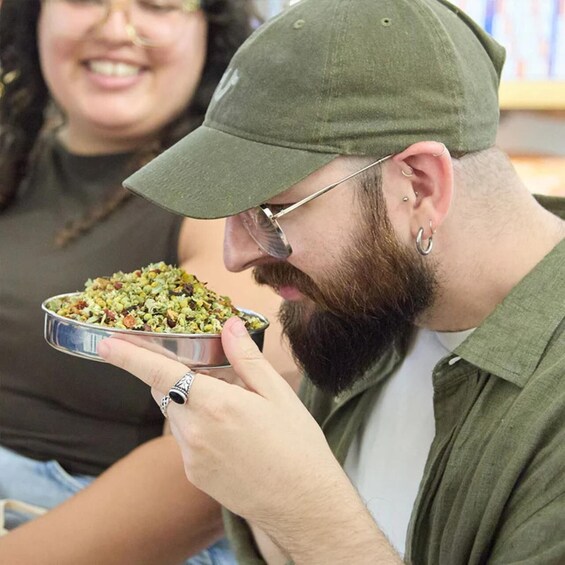 A person holding a metal bowl with a mixture of food items. 2