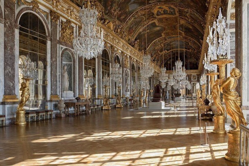 An opulent hall with grand chandeliers, marble columns, and classical statues. 3