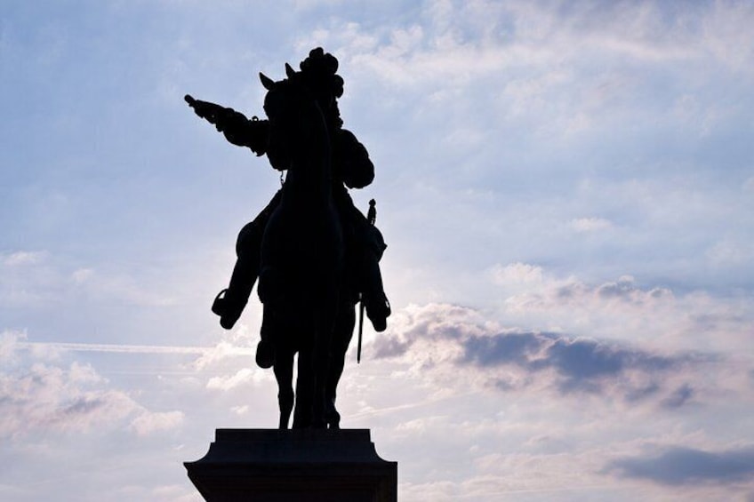 A silhouette of a statue against a cloudy sky. 1