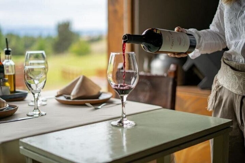 A person pouring wine into a glass. 5