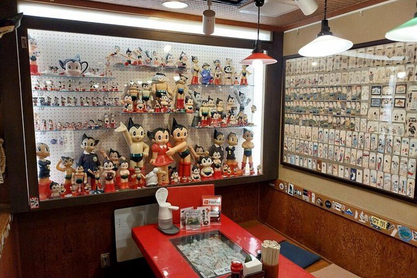 A store with shelves of figurines and a wall of postcards. 5