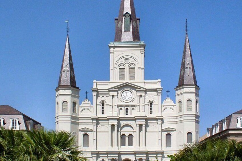 A white church with three spires and a clock. 5