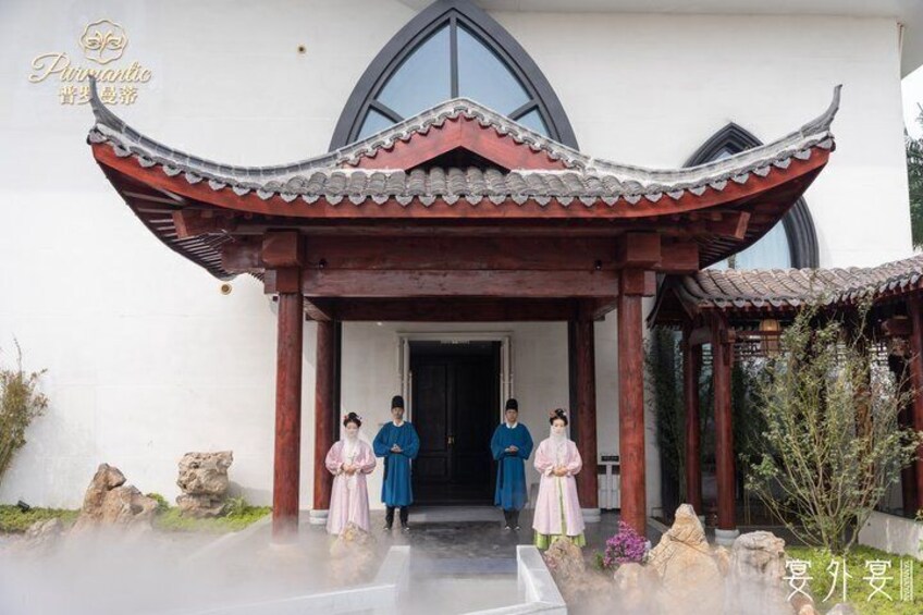 A traditional Chinese building with a curved roof and a stone statue in the foreground. 2