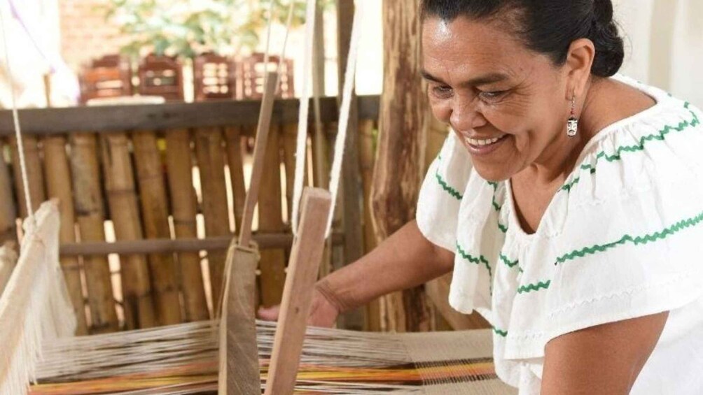 A person weaving on a loom. 5