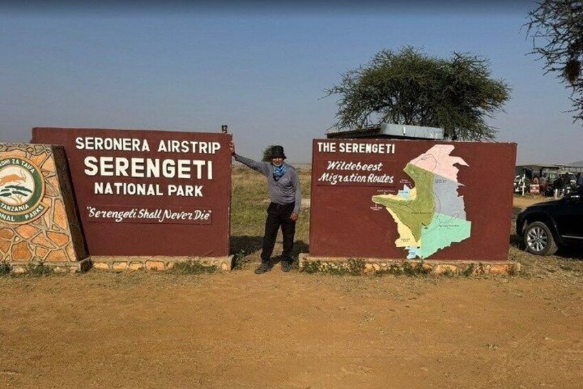 A sign for Serengeti Airstrip and Serengeti National Park with a map of migration routes. 1