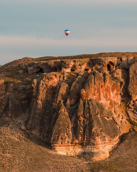 A hot air balloon over a rocky landscape with layered rock formations. 4