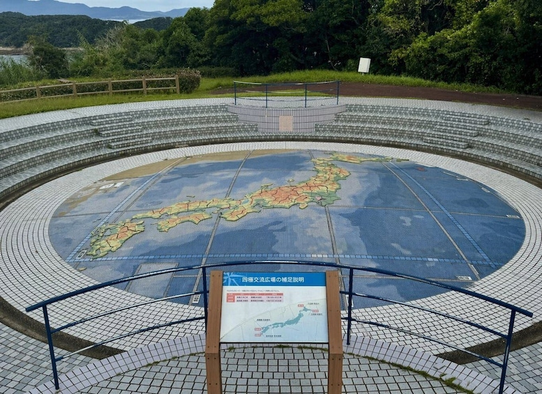 A circular outdoor exhibit with a map of Japan, surrounded by a tiled walkway and metal railings. 3
